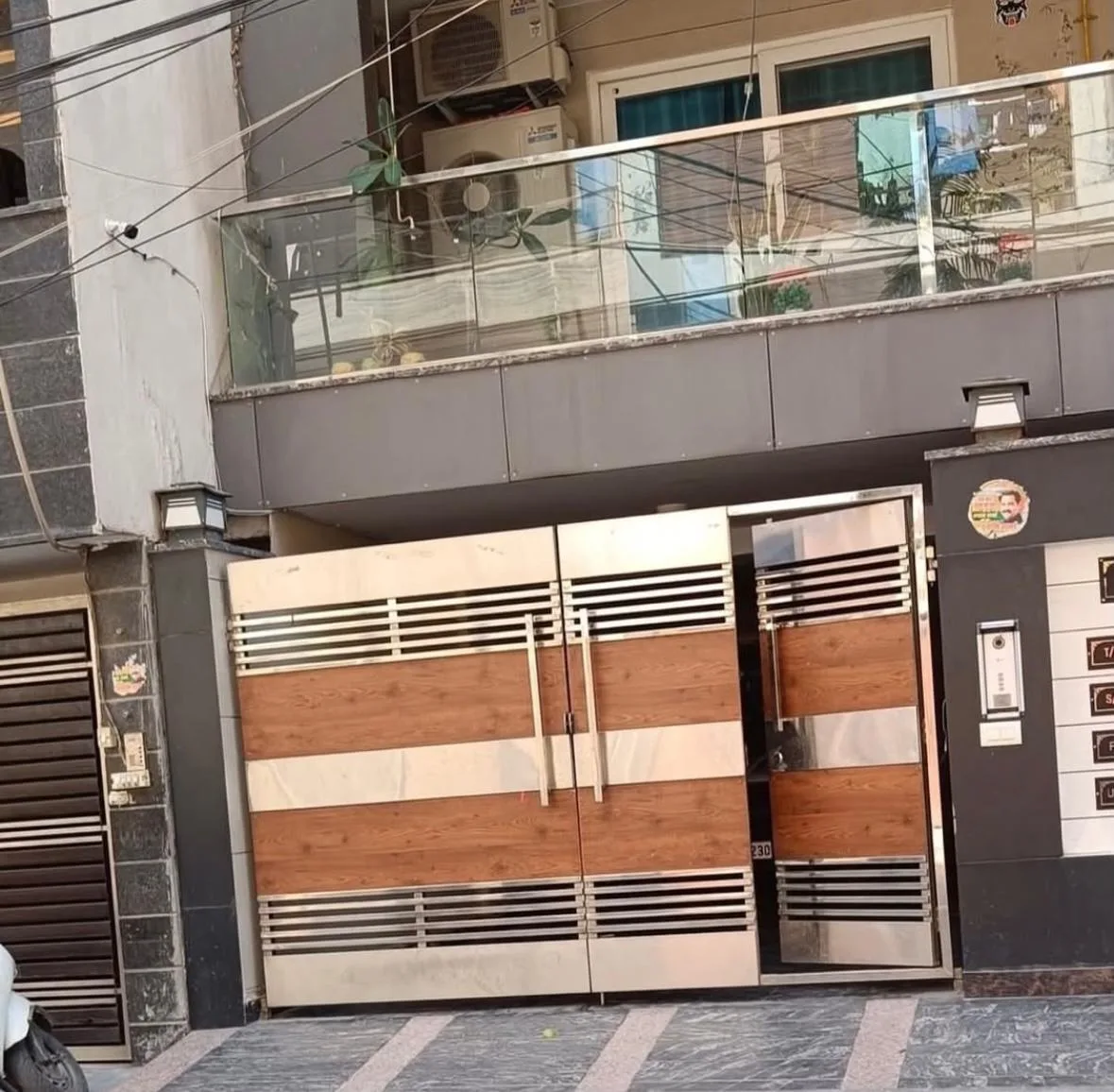 Residential gate with wood-finish panels and steel slats