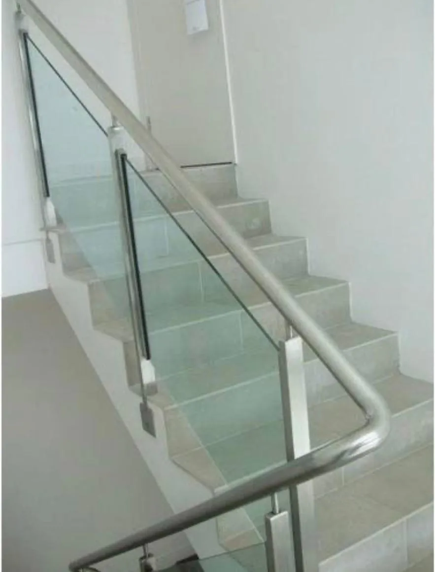 Frameless glass staircase railing with round handrail