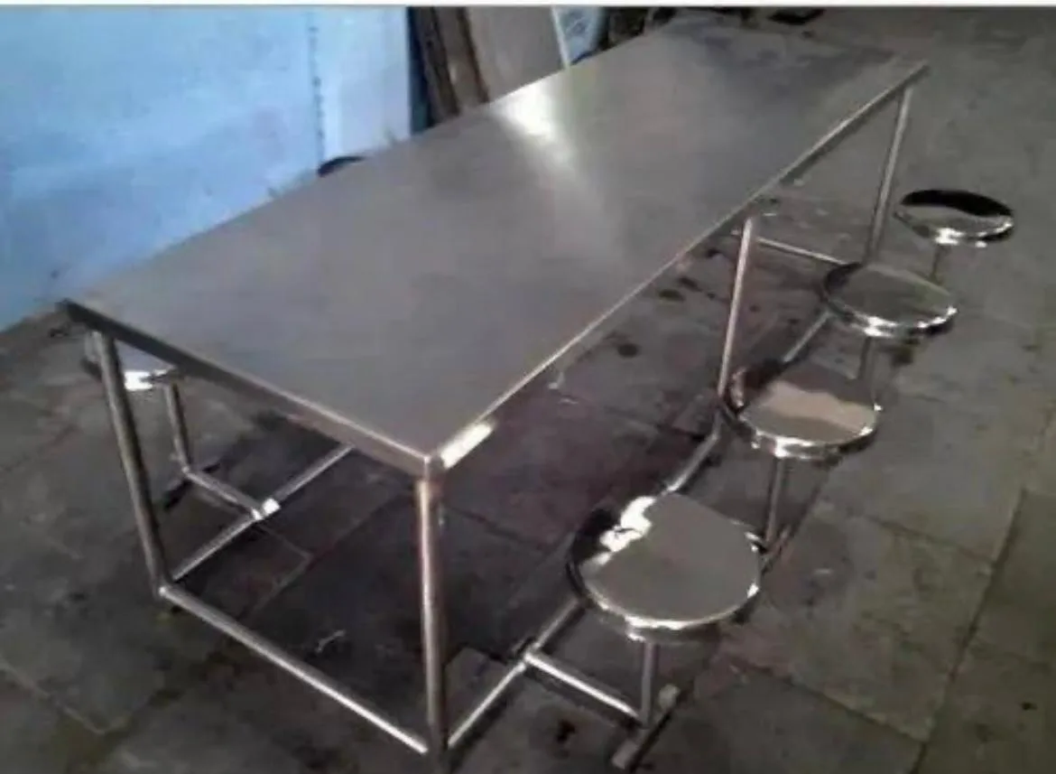 Stainless steel table with fixed round stools